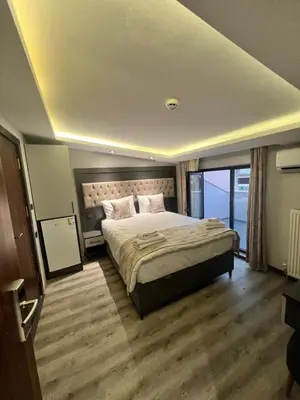 a bedroom with a large bed and a large window at Golden Stoneluxe İstanbul Hotel in Istanbul