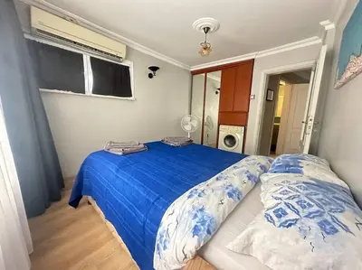 a bedroom with a bed with blue sheets and a window at 5 Min Walk Distance Taksim Square Semi Sea View in Istanbul