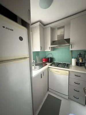 a kitchen with a white refrigerator and a sink at 5 Min Walk Distance Taksim Square Semi Sea View in Istanbul