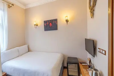 a small bedroom with a bed and a tv at BeyPort Hotel Istanbul in Istanbul