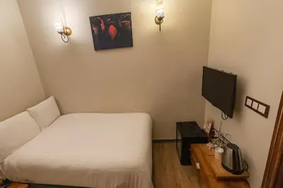 a small room with a bed and a tv at BeyPort Hotel Istanbul in Istanbul