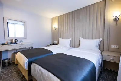 a hotel room with two beds and a window at Moss Hotel YENİKAPI in Istanbul