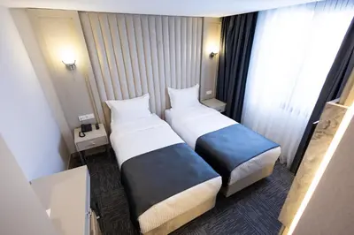 a hotel room with two beds and a window at Moss Hotel YENİKAPI in Istanbul