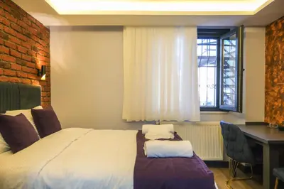 a bedroom with a bed and a desk and a window at Yellow Mansion in Istanbul