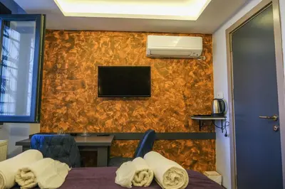 a room with a bed and a tv on a wall at Yellow Mansion in Istanbul