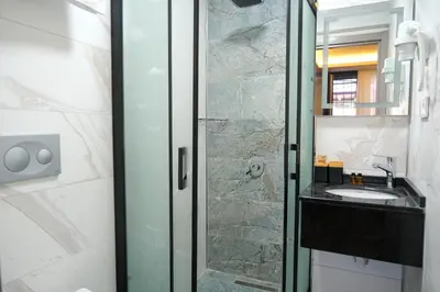 a bathroom with a glass shower with a sink at Yellow Mansion in Istanbul