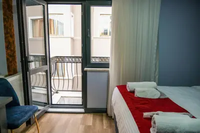 a bedroom with a bed with a red blanket and a balcony at Yellow Mansion in Istanbul