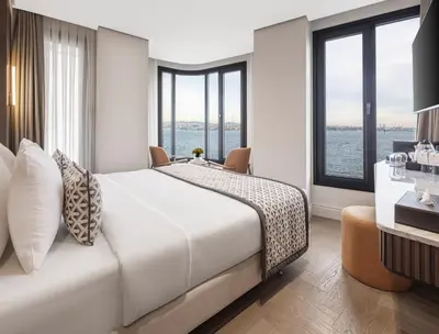 a bedroom with a large bed and large windows at Dream Inn Karaköy Bosphorus in Istanbul