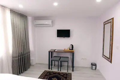 a room with a table with two chairs and a television at Pera Apart in Istanbul