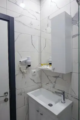 a white bathroom with a sink and a mirror at Pera Apart in Istanbul