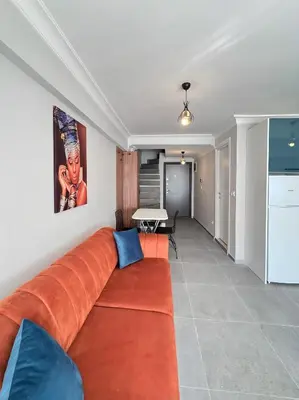 a living room with an orange couch and a table at ERDEM in Istanbul
