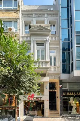 a tall white building with a store in front of it at ERDEM in Istanbul