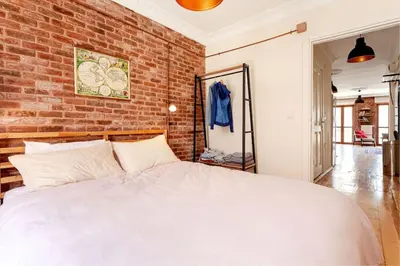 a bedroom with a white bed and a brick wall at Central location with 2 bedrooms in Istanbul