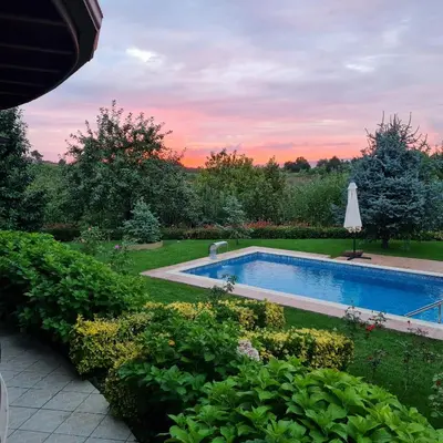 a swimming pool in a garden at sunset at Bizim Ev in Sapanca