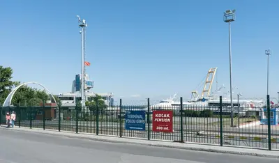 a black fence with signs on the side of a street at Koçak Pansiyon in Istanbul