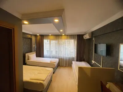 a hotel room with two beds and a television at Ufuk Hotel in Istanbul