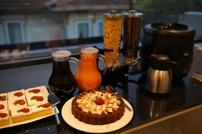 a table with a cake on a plate and some drinks at HaciBayramApart in Istanbul