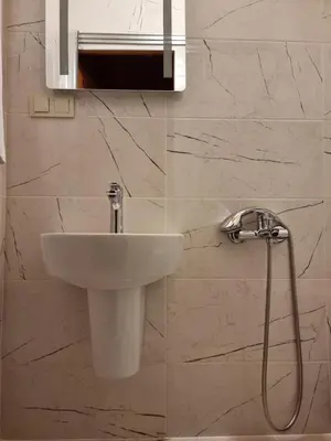 a white sink in a bathroom with marble walls at HaciBayramApart in Istanbul