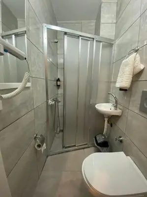 a bathroom with a shower and a toilet and a sink at Kadıköy Miski Amber in Istanbul