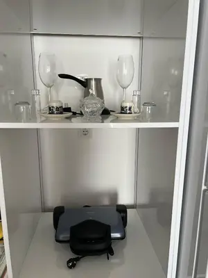 a shelf with a table and two glasses on it at Cozy Home 1 Room 1 Living Room Apartment in Esenyurt