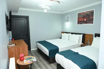 a hotel room with two beds and a table at Asgard Hotel in Beylikduzu