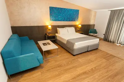 a hotel room with a bed and a blue chair at Fesa Business Hotel in Gebze