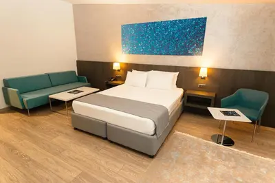 a hotel room with a bed and two chairs at Fesa Business Hotel in Gebze