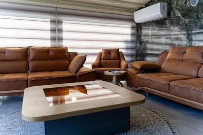 a living room with brown leather couches and a coffee table at Avcı Palace Hotel in Istanbul