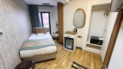 a small room with a bed and a mirror at Avcı Palace Hotel in Istanbul