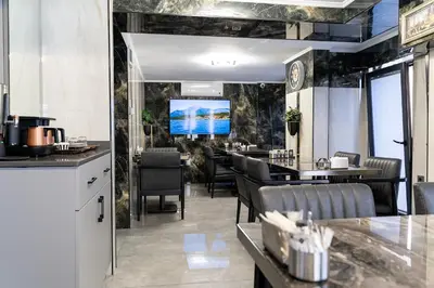 a restaurant with tables and chairs and a tv on the wall at Avcı Palace Hotel in Istanbul