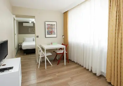 a room with a table and a bed and a window at Stay Juno in Istanbul
