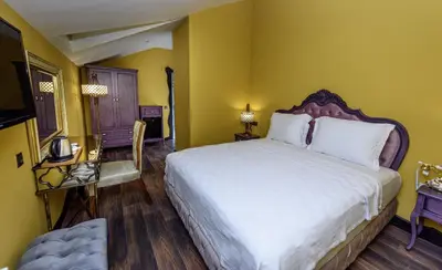 a bedroom with a large bed and yellow walls at TOK EPİK HOTEL in Bursa