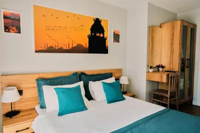 a bedroom with a bed with blue and white pillows at Taksim Santa Lucia Hotel in Istanbul