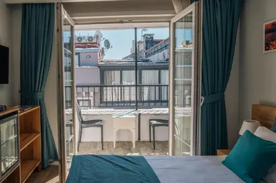 a bedroom with a bed and a balcony with a table at Taksim Santa Lucia Hotel in Istanbul