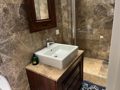 a bathroom with a white sink and a shower at 4+1 daire in Istanbul