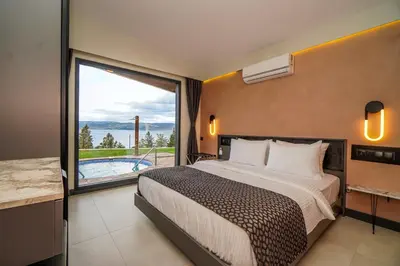 a bedroom with a large bed and a large window at Lake Look Sapanca in Sapanca