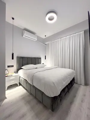 a white bedroom with a large bed and a window at Galata Inn Hotel in Istanbul