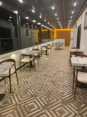 a restaurant with tables and chairs on a tiled floor at The rooms hotel in Kumbağ