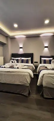 a room with three beds and lights on the wall at SAND DOOR HOTEL in Istanbul