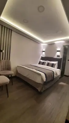 a bedroom with a large bed and a chair at SAND DOOR HOTEL in Istanbul