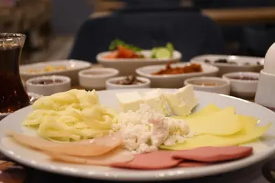 a plate with cheese and other foods on a table at Cibali Hotel Istanbul in Istanbul