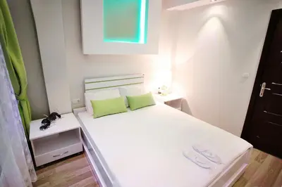 a small bedroom with a white bed with two green pillows at Balance Hotel Taksim in Istanbul