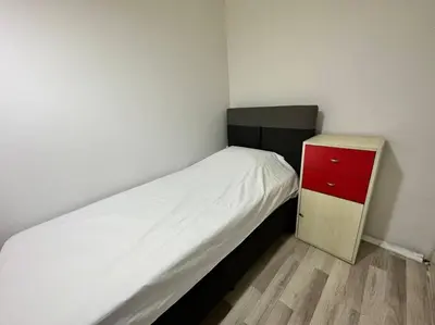 a small bedroom with a bed and a red cabinet at Taksim Cihangir'de 2+1 daire in Istanbul