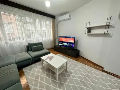 a living room with a couch and a table and a tv at Taksim Cihangir'de 2+1 daire in Istanbul