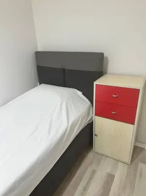 a small bed with a red dresser next to it at Taksim Cihangir'de 2+1 daire in Istanbul