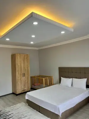 a bedroom with a large white bed and a cabinet at Ozn Suit Airport Hotel in Arnavutköy