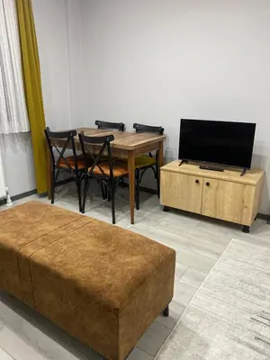 a living room with a table and a flat screen tv at Ozn Suit Airport Hotel in Arnavutköy