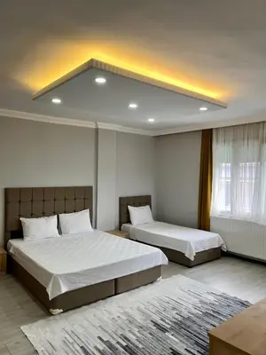 a bedroom with two beds and a large window at Ozn Suit Airport Hotel in Arnavutköy