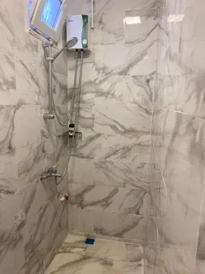 a bathroom with a shower with white marble walls at yenikapı HOTEL in Istanbul