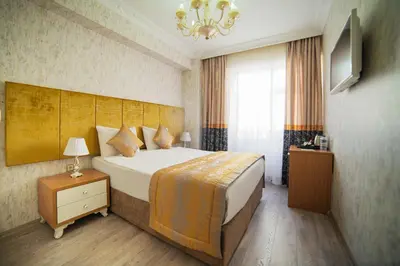 a hotel room with a large bed and a chandelier at Istanbul Old City Sultanahmed Miran Hotel in Istanbul